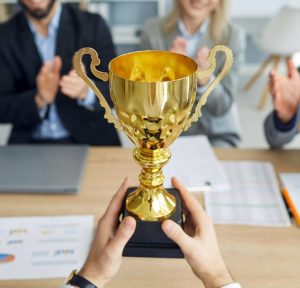Business team celebrating channel management success with trophy for top performance and partner achievement