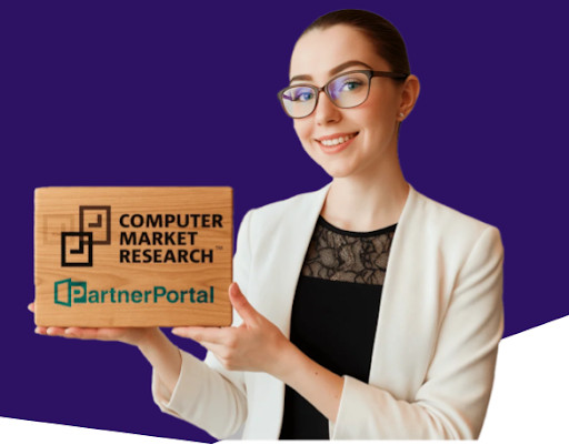 Smiling business professional holding a wooden sign displaying the Computer Market Research logo and PartnerPortal branding, representing partner relationship management and channel partner solutions.